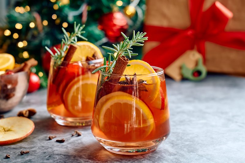 Punsch im Glas mit Orangenscheiben und Zimtstange